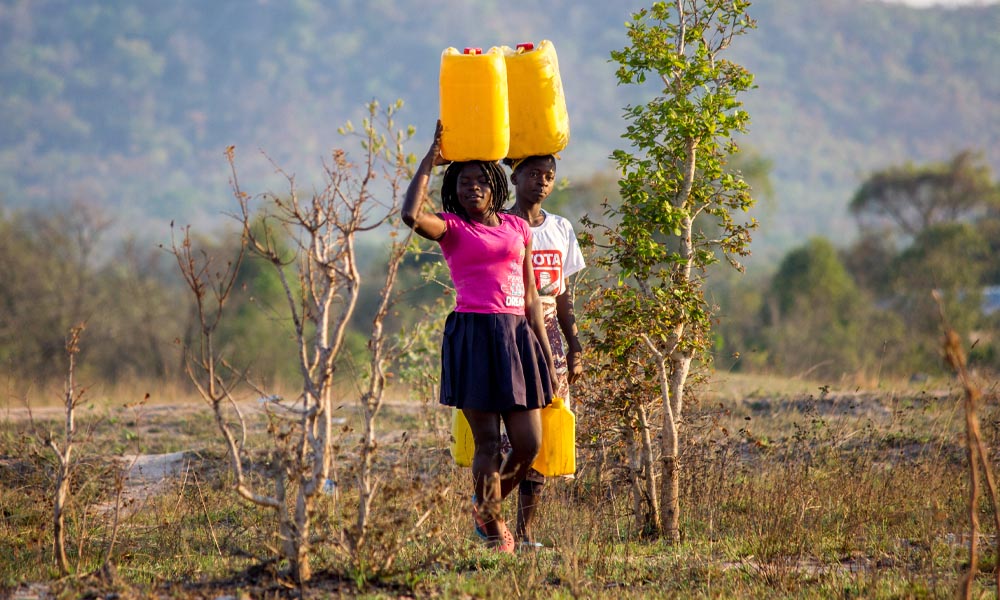 Crianças transportando água potável em Manica, Moçambique.