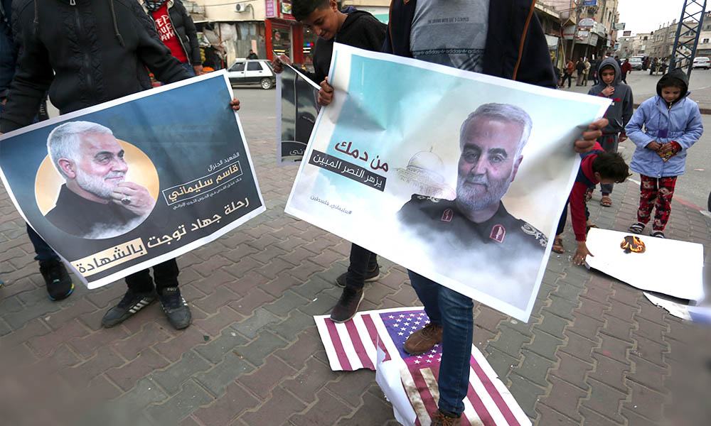 Palestinos queimam bandeiras dos EUA e de Israel e seguram cartazes do terrorista Qassem Soleimani, morto em um ataque de drones dos EUA, durante um protesto na Faixa de Gaza.